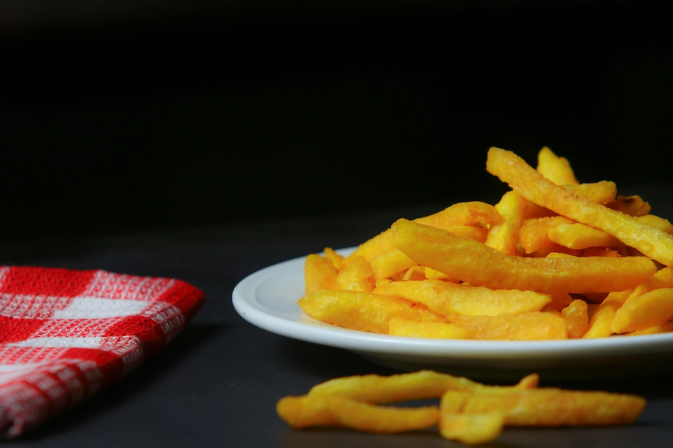 Yellow fries on a plate by Shourav Sheikh